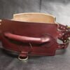 Rear three-quarter view of the Burgundy English Bridle leather Owned Riding Belt showing the raised control handle and attachment hardware.