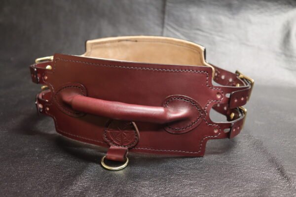 Rear three-quarter view of the Burgundy English Bridle leather Owned Riding Belt showing the raised control handle and attachment hardware.