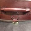Burgundy English Bridle leather Owned Riding Belt shown from the back to highlight the shaped body, handle, and brass connection points.