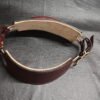 Burgundy English Bridle leather Owned Riding Belt shown from the inside with light leather lining and solid brass hardware, standing on its own to demonstrate the belt’s structured, body-shaped construction.
