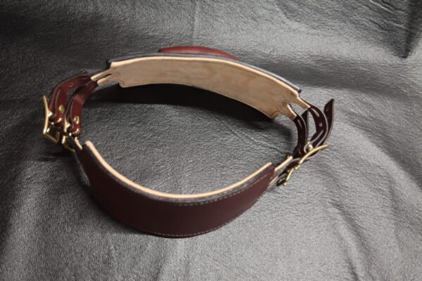 Burgundy English Bridle leather Owned Riding Belt shown from the inside with light leather lining and solid brass hardware, standing on its own to demonstrate the belt’s structured, body-shaped construction.