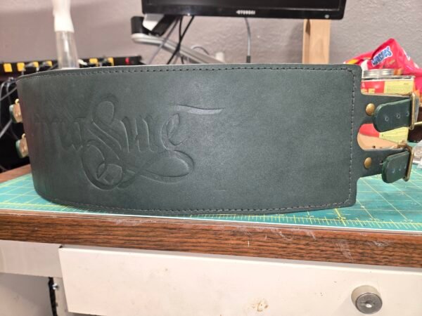 Front view of the dark green leather Owned Riding Belt “Treasure Belt” with “Treasure” embossed across the front panel.