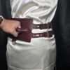 Burgundy English Bridle leather Owned Riding Belt worn at the waist with solid brass buckles and D-ring, shown while the raised control handle is being gripped.