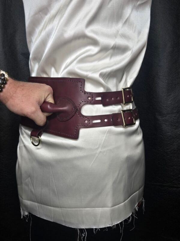 Burgundy English Bridle leather Owned Riding Belt worn at the waist with solid brass buckles and D-ring, shown while the raised control handle is being gripped.