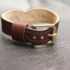 Drop Tip Sigil Collar Burgundy 5 Rear closure detail of the Burgundy English Bridle Drop Tip Sigil Collar, showing the solid brass buckle, adjustment holes, keeper loop, and natural lambskin lining.