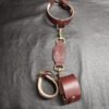 Drop Tip Sigil Collar Tethered to Owned Riding Cuffs Burgundy English Bridle Drop Tip Sigil Collar connected by a leather tether to matching Owned Riding Cuffs with solid brass hardware and natural lining.