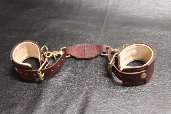 Cuff Set Connected 3 Black leather Owned Wrist Cuffs connected by a matching tether and laid out on a light background.